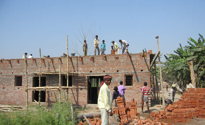 Photo des travailleurs qui construisent le toit de la nouvelle &eacute;cole